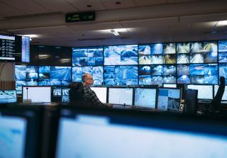 Tieliikennekeskus, jossa tieliikenneohjaaja valvomassa sujuvaa liikennettä monitoreilta.