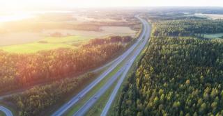 Kesäinen valtatie metsämaiseman ympäröimänä.