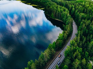 Kesäinen ilmakuva maantiestä, metsästä ja järvestä
