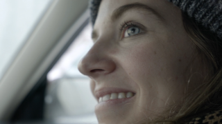 Hymyilevät naisen kasvot autossa