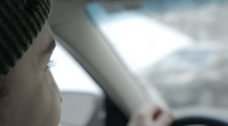 Lähikuva miehestä, joka ajaa autolla